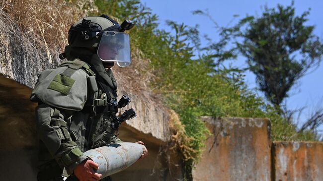 Сапер группы разминирования сводного отряда Международного противоминного центра ВС России обезвреживает мост на дороге в Мариуполь в районе поселка Коминтерново