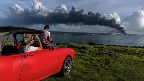 Люди наблюдают за пожаром на нефтехранилище в провинции Матансас, Куба