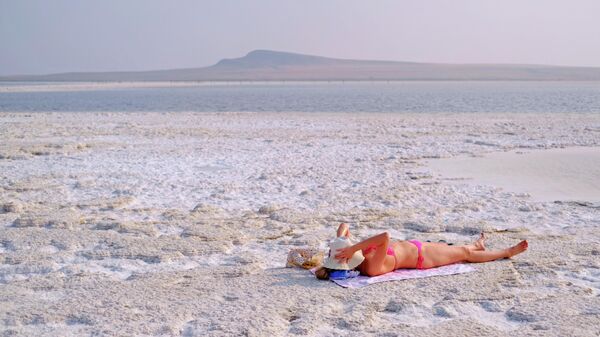 Девушка загорает в зоне отдыха на соленом озере Баскунчак