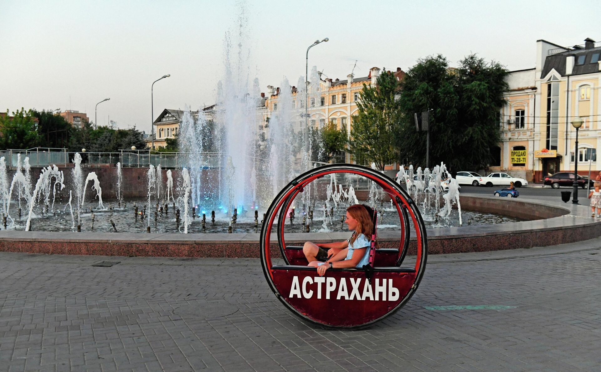 Туристы катаются на фоне светомузыкального фонтана на Петровской набережной в Астрахани