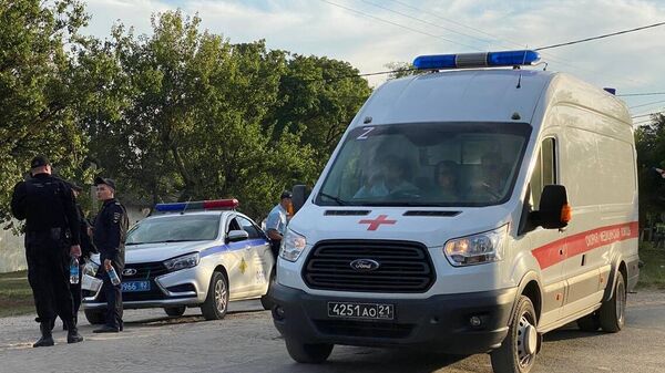 Сотрудники полиции и машина скорой помощи в окрестностях крымского поселка Новофедоровка после случившихся там взрывов