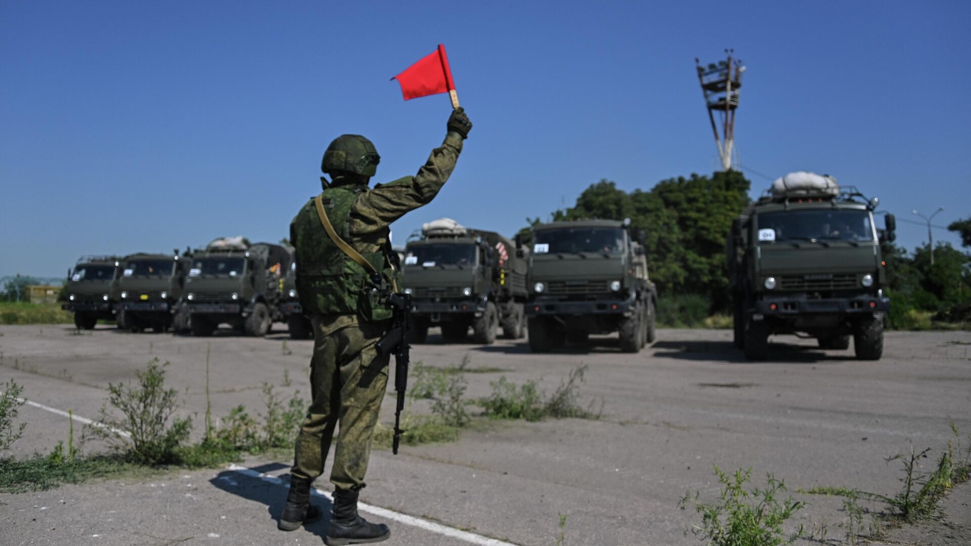 Военнослужащий подает сигналы флажком для проезда военной техники в Мариуполе - РИА Новости, 1920, 15.08.2022