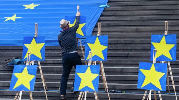 Мужчина устанавливает звезды на флаге ЕС 