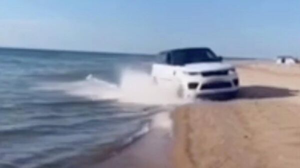 Кадр видео с автомобилем, который движется по водному массиву озера Байкал