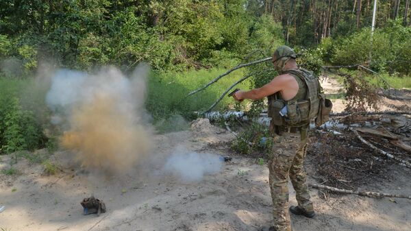 Служащий НМ ДНР расстреливает противопехотную фугасную мину ПМФ-1 Лепесток, обнаруженную на дороге у села Избицкое Харьковской области