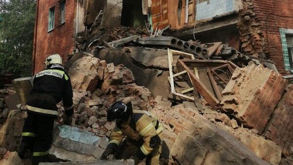 Сотрудники пожарной охраны на месте обрушения части жилого дома в Омске
