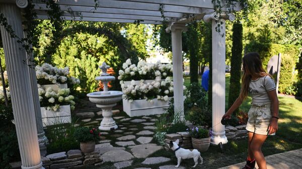 Девушка прогуливается с собакой во время VIII Московского международного фестиваля ландшафтного искусства Сады и люди в Северном сквере на ВДНХ
