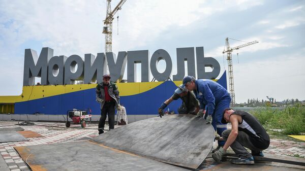 Рабочие устанавливают стелу на въезде в Мариуполь