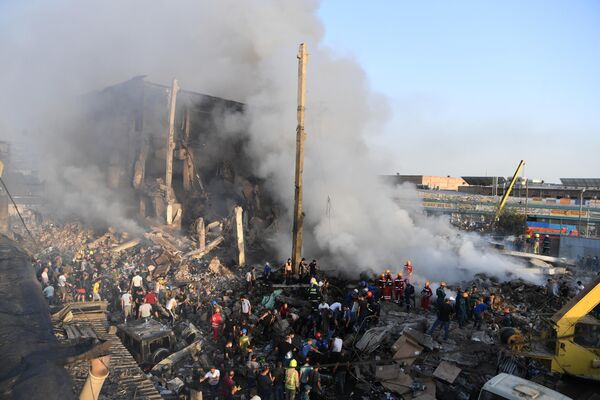 Местные жители, пожарные и сотрудники МЧС разбирают завалы на месте взрыва у торгового центра Сурмалу в Ереване
