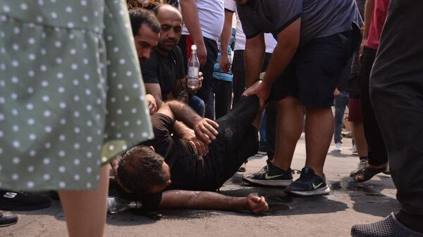 Местные жители оказывают помощь мужчине, пострадавшему от взрыва у торгового центра Сурмалу в Ереване