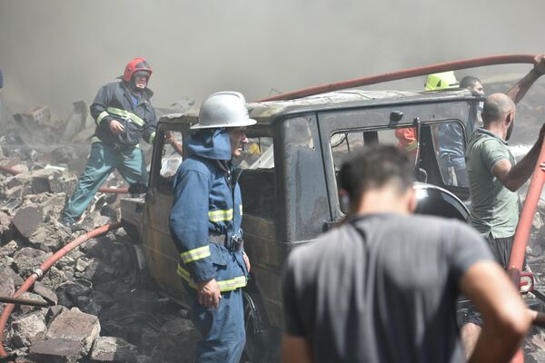 Местные жители и пожарные на месте взрыва у торгового центра Сурмалу в Ереване