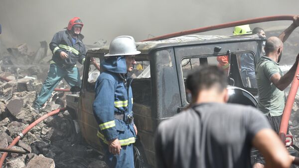 Местные жители и пожарные на месте взрыва у торгового центра Сурмалу в Ереване