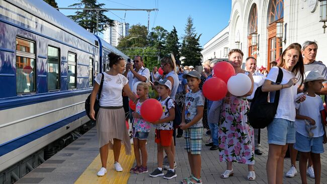 Пассажиры у туристического поезда Сочи сообщением Туапсе – Сочи – Гагра на платформе железнодорожного вокзала города Сочи