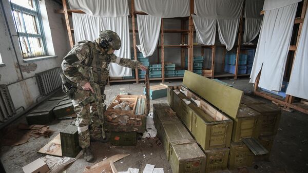 Военнослужащий ВС РФ осматривает боеприпасы, оставленные ВСУ. Архивное фото