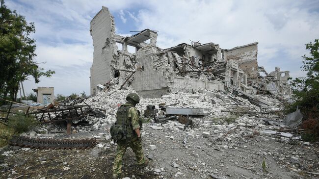 Военнослужащий ВС России возле разрушенного дома в селе Александровка Херсонской области