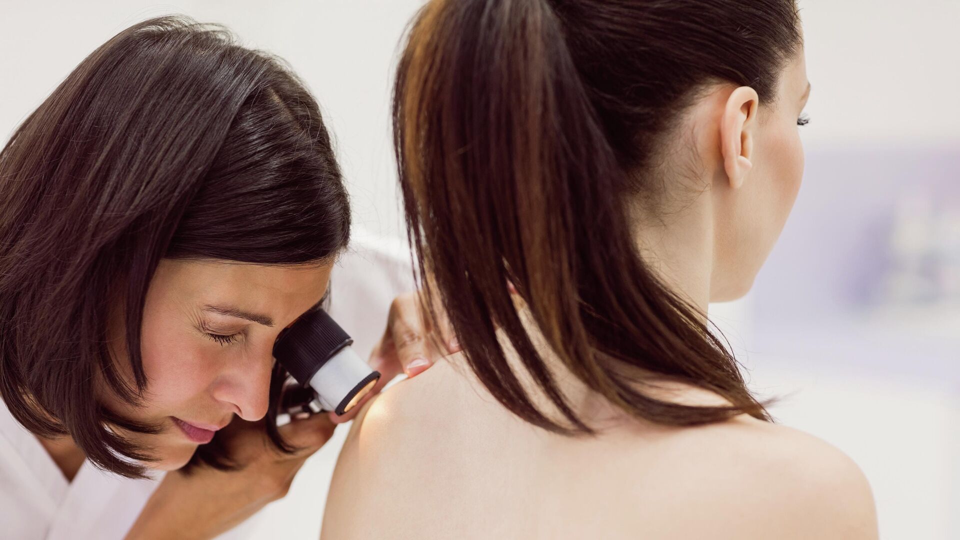 Дерматолог осматривает кожу пациента с помощью дерматоскопа - РИА Новости, 1920, 24.09.2022