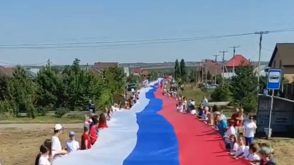 Развертывание российского флага длиной 1300 метров в селе Подгородняя Покровка Оренбургской области