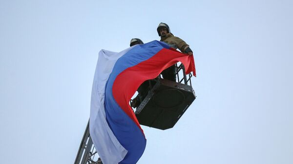 Спасатели МЧС ДНР поднимают флаг РФ над центром Донецка