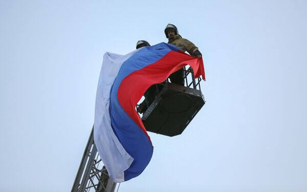 Спасатели МЧС ДНР поднимают флаг РФ над центром Донецка
