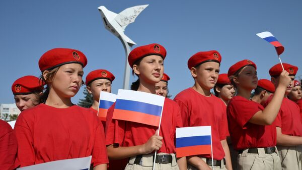 Members of the military-patriotic movement Young Guard - Yunarmiya hold a rally in Donetsk dedicated to the Day of the State Flag of the Russian Federation