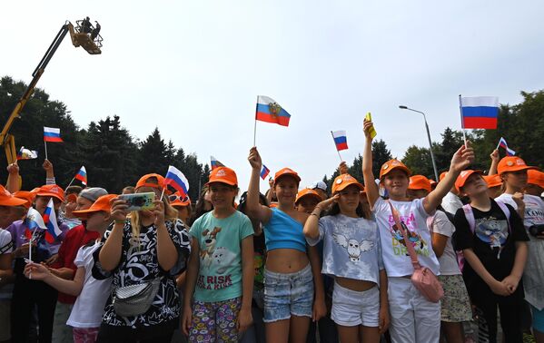 Школьники наблюдают за церемонией развертывания триколора площадью 1 тысячу квадратных метров в День Государственного флага России у Музея Победы в Москве