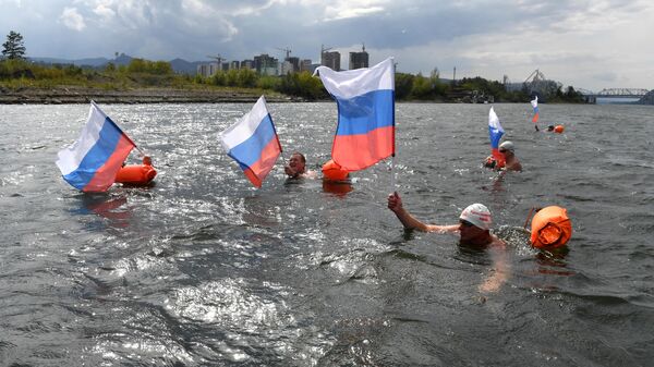 Members of the winter swimming club Yenisei walruses swimming in cold water in honor of the Day of the State Flag of the Russian Federation in Krasnoyarsk