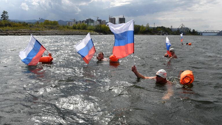 Участники клуба зимнего плавания Енисейские моржи во время заплыва в холодной воде в честь Дня государственного флага РФ в Красноярске