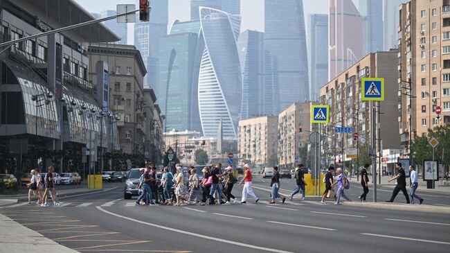 Люди переходят дорогу на Большой Дорогомиловской улице в Москве