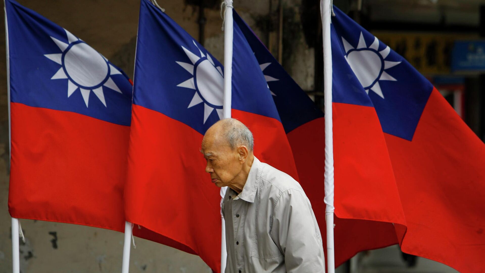 Мужчина проходит мимо флагов Тайваня в Тайбэе - РИА Новости, 1920, 15.01.2024