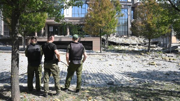 Военнослужащие около здания администрации главы Донецкой народной республики, поврежденного в результате обстрела ВСУ в Донецке