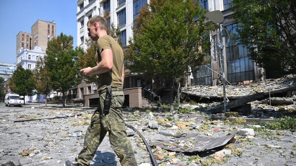 Военнослужащий около здания администрации главы Донецкой народной республики, поврежденного в результате обстрела ВСУ в Донецке
