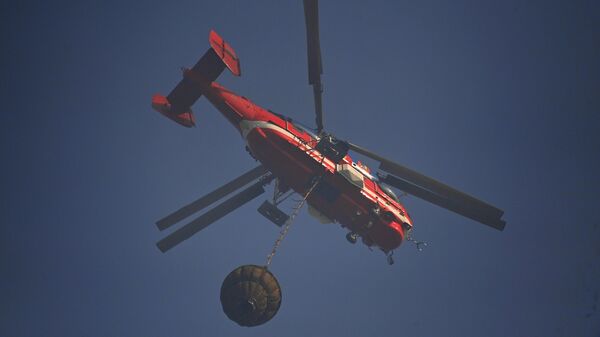 Пожарный вертолет МЧС РФ принимает участие в тушении лесного пожара
