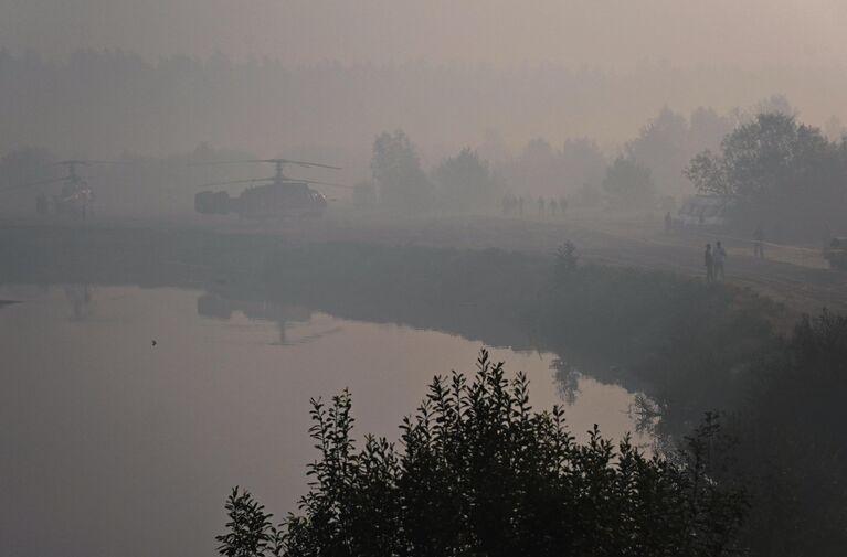 Вертолеты МЧС у водоема среди леса в Рязанской области, пострадавшего от пожара