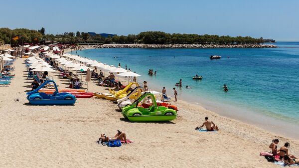 Люди отдыхают на городском пляже Алимос в пригороде Афин