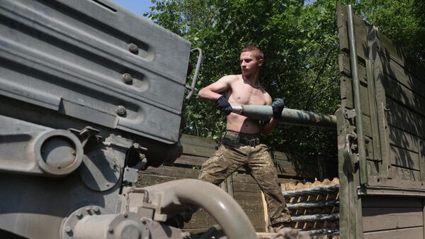Украинский артиллерист заряжает реактивную систему залпового огня БМ-21 Град