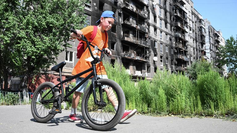 Мальчик катается на велосипеде в Мариуполе