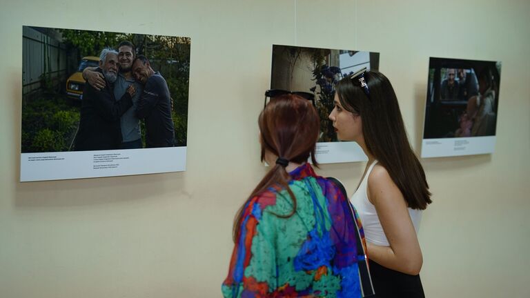 Посетители на выставке фотографий специального фотокорреспондента МИА Россия сегодня Валерия Мельникова Возвращение домой в Галерее искусств Луганского художественного музея