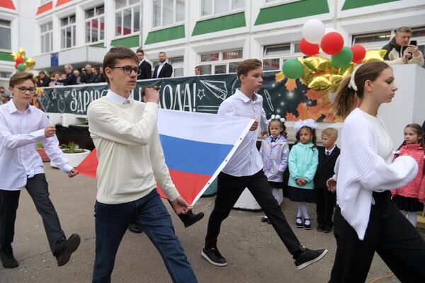 Учащиеся во время церемонии поднятия государственного флага России на торжественной линейке в День знаний, проходящей в школе №1619 имени М. И. Цветаевой в Москве