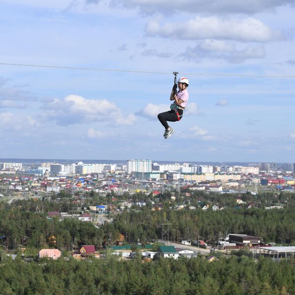 Девушка на аттракционе Zipline в парке Урдэл в Якутске