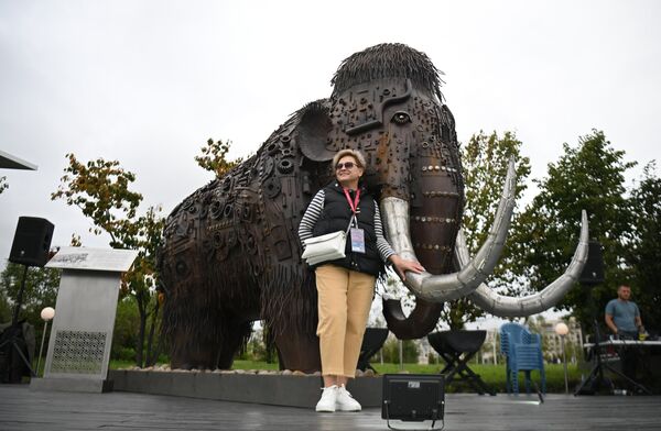 Участница Восточного экономического форума во Владивостоке фотографируется у скульптуры мамонта