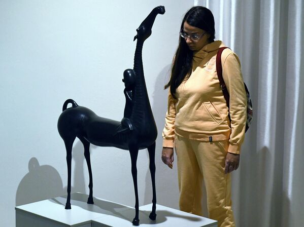 Посетительница рассматривает бронзовую скульптуру Полет работы бурятского скульптора Даши Намдакова на его выставке Трансформация в Красноярске