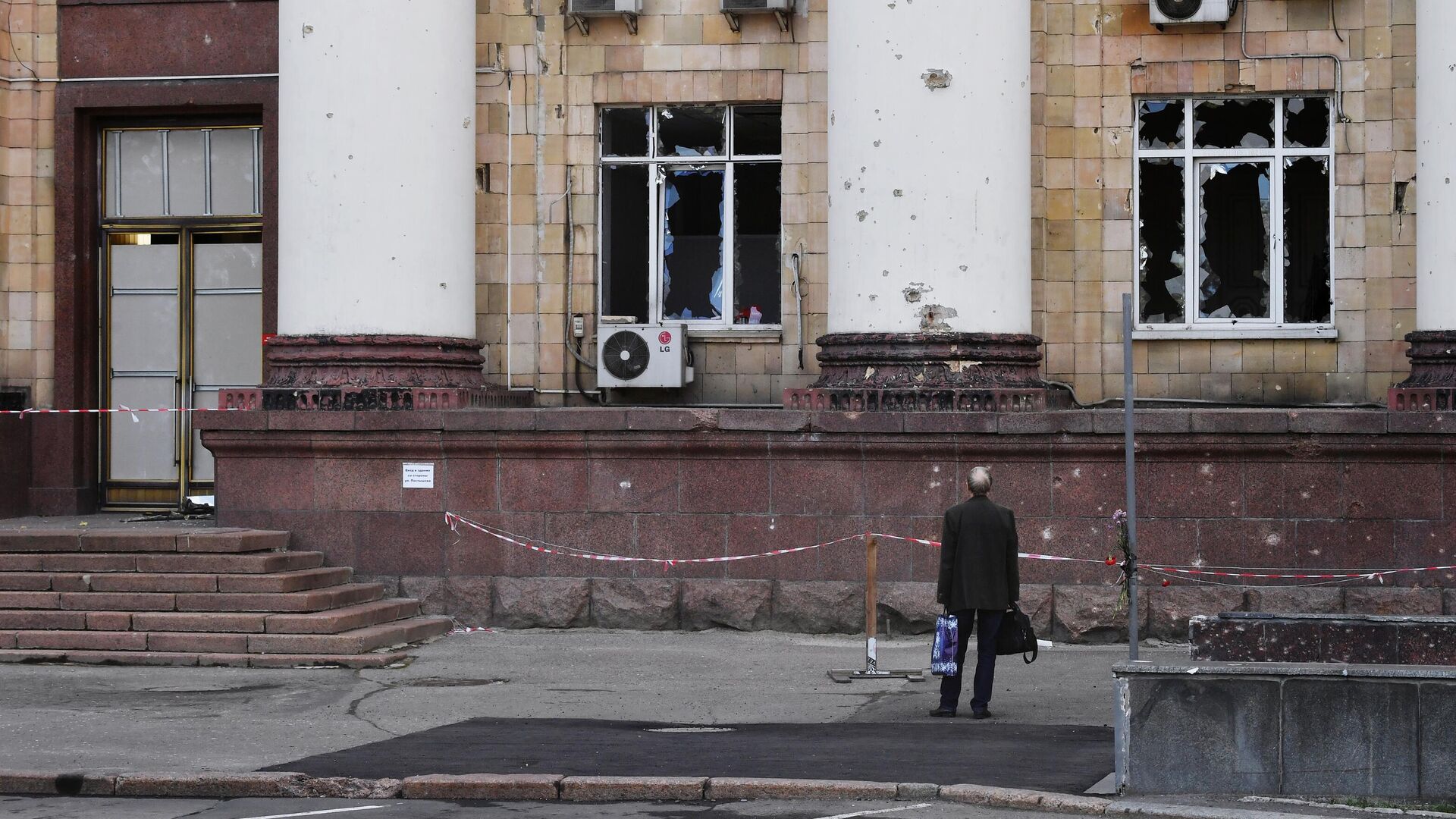 Мужчина возле частично разрушенного здания на одной из улиц в Донецке - РИА Новости, 1920, 08.09.2022