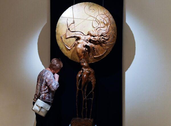 Посетительница возле бронзовой скульптуры Амазонки работы бурятского скульптора Даши Намдакова на его выставке Трансформация в Красноярске