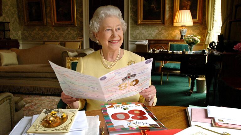 Королева Великобритании Елизавета II рассматривает открытки, присланные ей на ее 80-летие