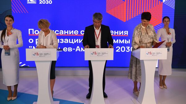 Дарья Кирьянова, Алексей Цыденов и Ольга Семенова подписывают соглашение в рамках программы реализации проекта Муравьев-Амурский 2030 на Восточном экономическом форуме во Владивостоке