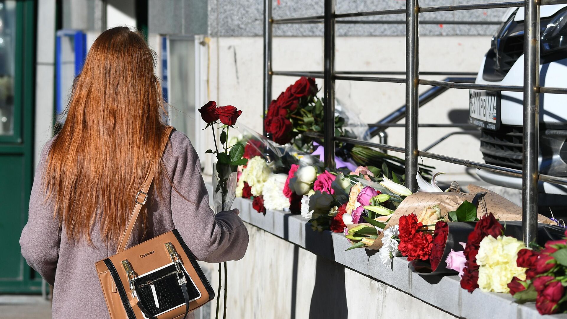 Девушка несет цветы в память о королеве Елизавете II к зданию посольства Соединенного королевства Великобритании и Северной Ирландии в Москве - РИА Новости, 1920, 13.09.2022