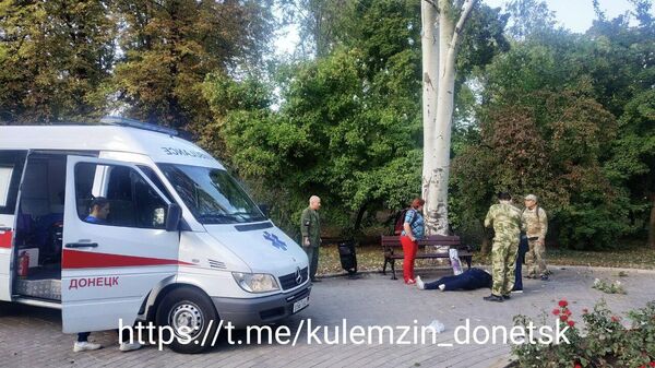 Медики оказывают помощь женщине, пострадавшей в результате обстрела Парка кованых фигур в Донецке. 9 сентября 2022