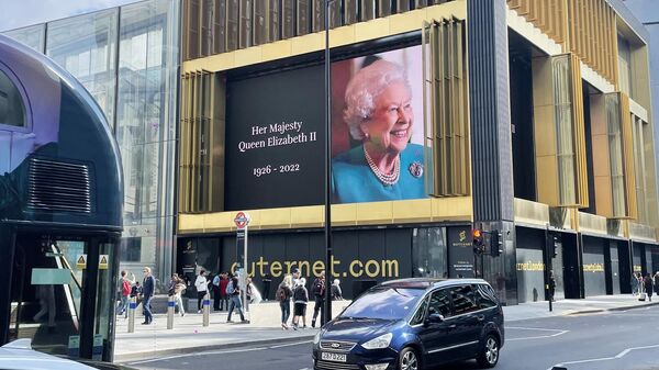 Экран с изображение королевы Елизаветы II на фасаде здания на одной из улиц в Лондоне