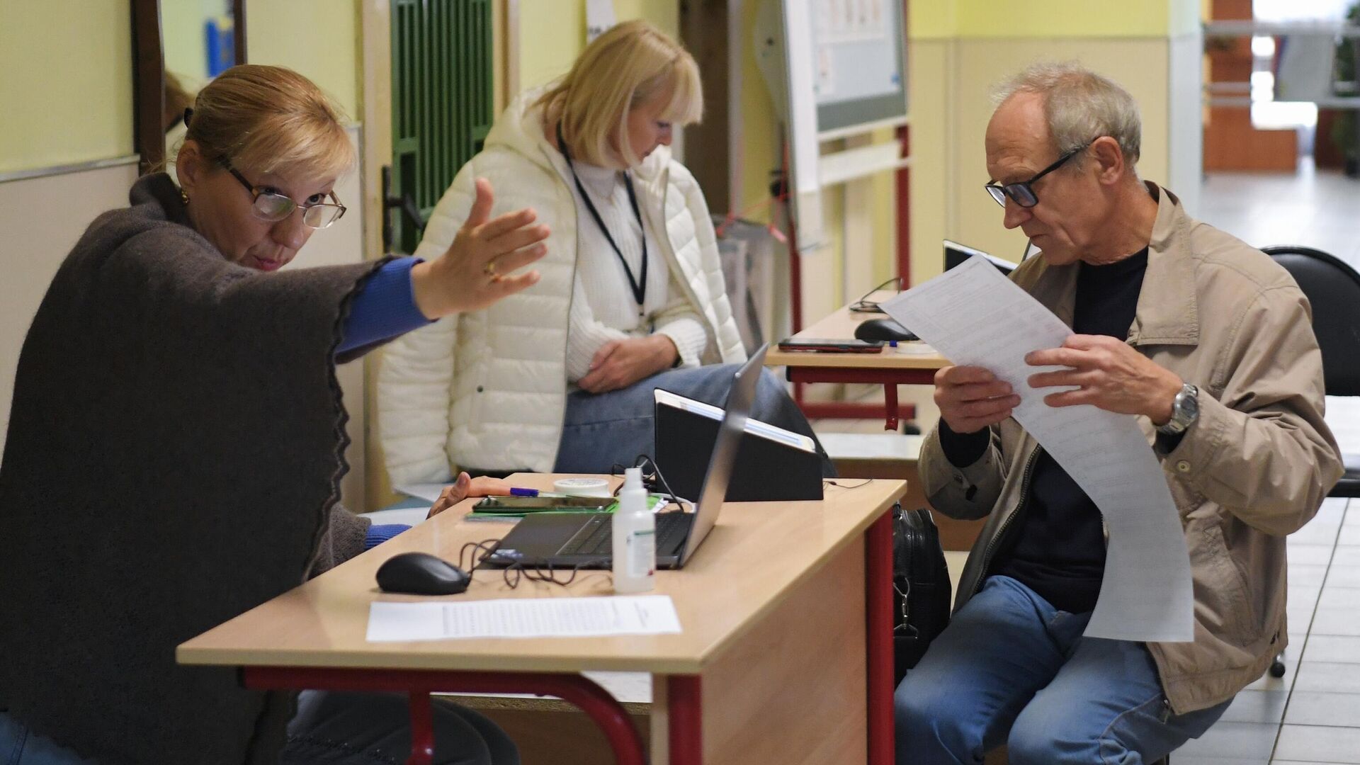 Мужчина получает бюллетень для голосования на избирательном участке в Москве - РИА Новости, 1920, 11.09.2022