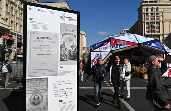 Люди возле фотографий на фотовыставке агентства РИА Новости на Моховой улице в Москве